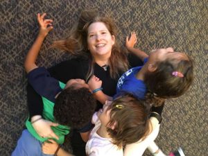 Cantor-with-kids-o Cantor Adesnik tackled on the floor by three Schiff Preschool children. Everyone is laughing and having fun.