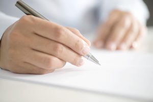Woman signing contract paper, horizontal