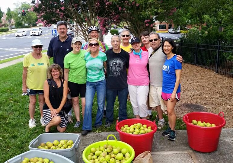 Volunteers working at the Community Action Center, bringing barrels of fruit.